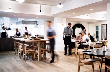 Sala do restaurante Kadeau com teto acústico Mute branco, contínuo, e equipa a servir